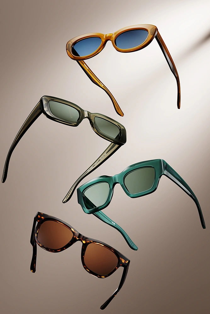 Four pairs of premium sunglasses floating against a warm beige backdrop