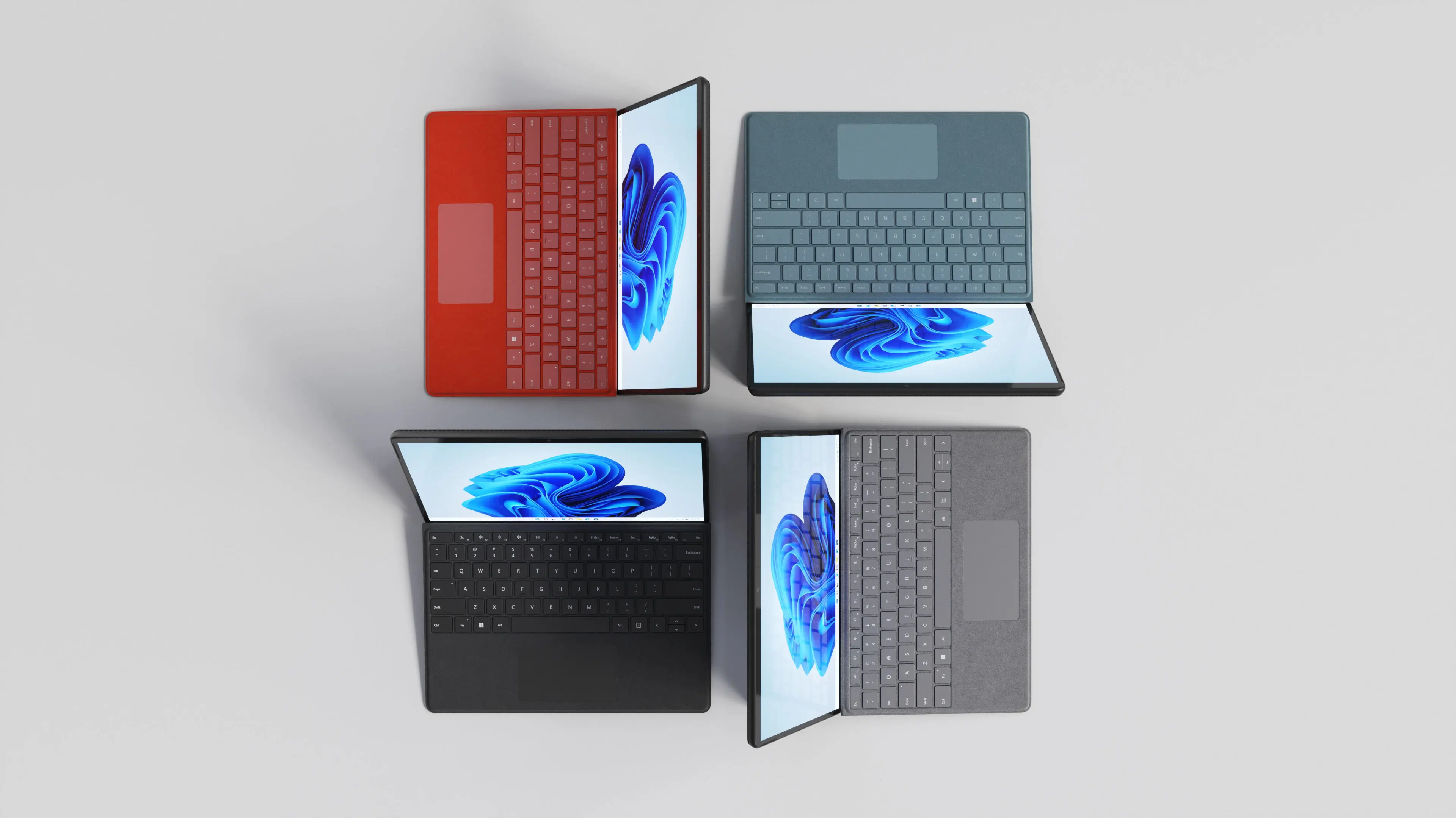 3D render of four Surface Pro 8 tablets with red, teal, black and gray keyboards, seen from above